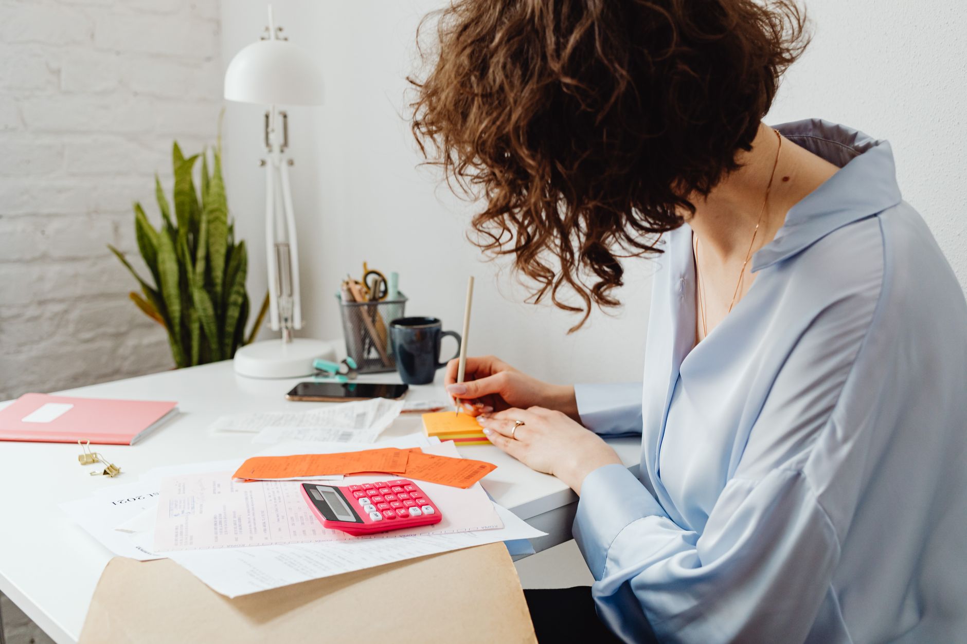 an accountant working through nonprofit finances at a home desk with a calculator